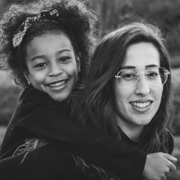 A young woman giving a girl a piggyback ride